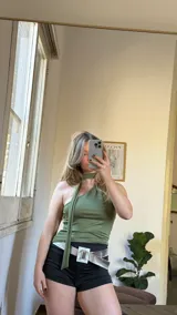 Top verde oliva de lycra con diseño asimétrico de un hombro, cuello choker y corbatín extraíble.
