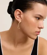 Par de caravanas doradas con forma de hilo, cadena serpiente colgante y detalle de strass en la base. Cierre con tornillo.