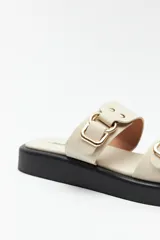 Sandalias marrones con plataforma baja y tiras anchas con hebillas metálicas.