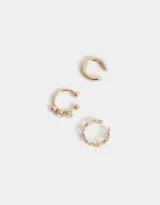 Set de tres aros cuff dorados para la oreja, con diferentes diseños: uno liso, uno con tres strass y uno con eslabones.