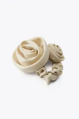 Coletero elástico color beige con dos flores grandes de tela en relieve.