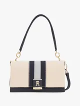 Cartera de lona color beige con rayas verticales azul marino y plateada. Tiene asa superior y correa extraíble y ajustable. El cierre es con solapa magnética y tiene el logo de Tommy Hilfiger en dorado.