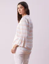 Blusa estampada a rayas horizontales en tonos celeste, blanco y naranja, con cuello mao, escote en V y abertura con botones. Delantero con punto smock. Manga ¾ con terminación amplia.