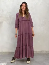 Vestido largo color morado, con escote en V, mangas largas y corte escalonado.