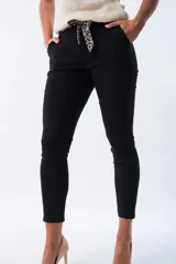 Pantalón negro de corte aline con cintura plisada y lazo estampado animal print.