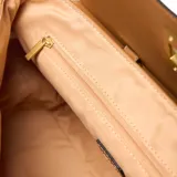 Cartera tipo satchel color habano (marrón claro), confeccionada en PU (simil cuero). Presenta solapa frontal con herraje metálico dorado, asa superior y correa larga regulable y desmontable. Incluye un dije con candado colgante.