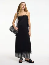 Vestido midi negro de estilo lencero con breteles finos regulables y encaje en el escote y ruedo.
