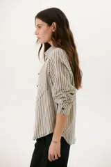 Camisa a rayas verticales color beige y blanco, con cuello clásico, botones marrones y mangas largas.
