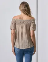 Blusa color beige de gasa bambula, marca Liv Los Ángeles. Escote recto con frunce y hombros descubiertos. Manga corta con detalles bordados.