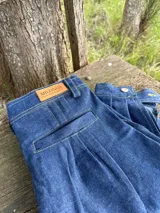 Pantalón de jean azul oscuro, de corte recto, con bolsillos laterales y traseros.