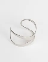 Brazalete rígido dorado con diseño geométrico abierto.