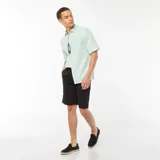 Camisa verde de manga corta con cuello clásico y cierre con botones.
