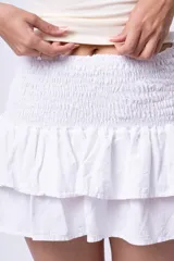 Minifalda blanca con cintura elastizada tipo nido de abeja y dos volados.