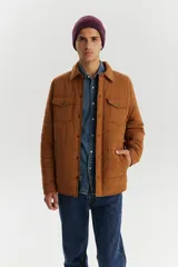 Campera marrón acolchada con cuello camisero, cierre frontal con botones a presión, dos bolsillos de parche en el pecho con solapa y dos bolsillos laterales.
