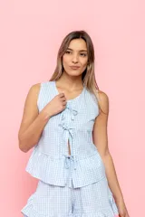 Blusa sin mangas con estampado de cuadros vichy celeste y blanco, con escote en V y lazos decorativos.