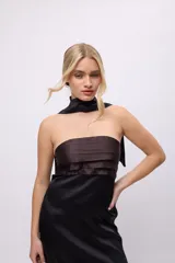 Vestido largo de satén negro con corpiño marrón con tablas y bufandín al cuello.