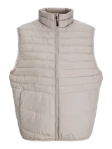 Chaleco puffer color beige con cuello alto, cierre frontal con cremallera, bolsillos laterales y diseño acolchado.