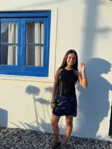 Minifalda dorada de cuero sintético, corte medio/bajo, con cortes en el delantero y pequeño tajo a un lado.