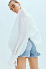 Short de denim celeste de tiro alto, con bolsillos frontales tipo parche y bolsillos traseros. Cierre frontal con botón metálico.
