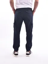 Pantalón jogger gris con bolsillos cargo laterales, cintura elastizada con cordón ajustable y puños elastizados.