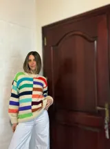 Sweater de lana merino con cuello redondo y diseño con motivos geométricos en tonos azul, marrón, naranja, verde y beige.