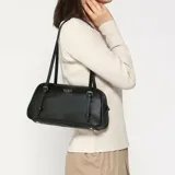 Bolso de hombro Guess modelo Cerelia, color negro, con logo plateado en el frente y herrajes plateados.