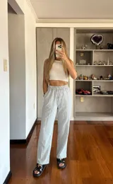 Pantalón de corte recto con estampado de rayas verticales en color celeste y blanco, con cintura elástica fruncida y bolsillos laterales.