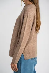 Sweater color marrón claro de tejido de punto, con cuello redondo y mangas largas.
