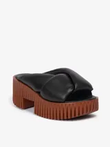 Sandalia tipo mule color negro, con plataforma marrón y tira ancha acolchada de cuero.