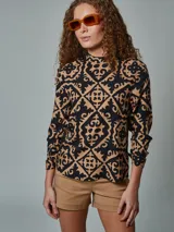 Blusa de cuello alto y manga larga con estampado geométrico en negro y beige.