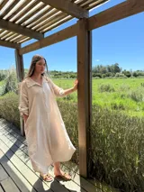 Vestido camisero amplio y largo de lino color azul, con botones de nácar, cuello camisero y bolsillos laterales.