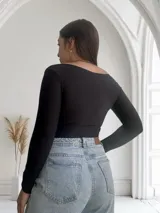 Body negro de mangas largas con escote en V cruzado.