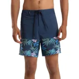 Boardshort de hombre, color azul marino, con diseño de bloques de color. La parte superior es lisa y la inferior presenta un estampado tropical de hojas y flores en tonos verde azulado y rosado pálido. Posee cordón de ajuste en la cintura.