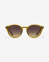 Lentes de sol unisex Hawkers modelo Salt, con montura redonda color verde oliva y lentes marrones degradadas.