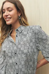 Camisa marrón con estampado animal print, cuello clásico, abotonadura frontal y mangas largas con puños elastizados.