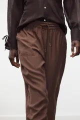Pantalón jogger marrón de tiro alto con cintura elástica ajustable con cordones, bolsillos delanteros y puños elásticos en los tobillos.