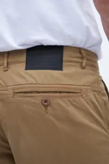 Pantalón cargo color verde oliva, con bolsillos laterales y bolsillo cargo con solapa y botones.