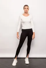 Legging negro con detalle de cortes frontales, pretina ancha y pequeñas aberturas en los pies.