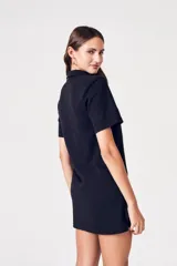 Vestido mini negro con botones al frente, confeccionado en una mezcla de algodón y elastano, diseñado para ofrecer comodidad y durabilidad.