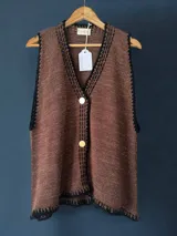 Chaleco tejido a mano con escote en V, bordado con botones, confeccionado en algodón con detalles de lurex. Terminaciones en crochet y bordados hechos a mano con lana merino.