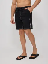 Short de baño negro con costuras blancas en contraste y logo de la marca en la pierna derecha.