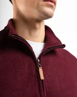 Sweater verde de punto con cuello alto y cierre medio con cremallera.