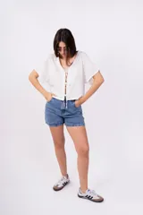 Remera color amarillo pálido de corte holgado, escote en V con lazo y mangas cortas.