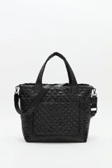 Bolso tote grande acolchado color vino tinto, con costuras en patrón de rombos. Posee dos asas de mano y una correa ajustable y desmontable con texto repetido. Incluye un charm colgante con letras negras.