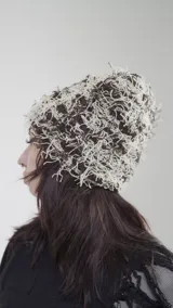 Gorro de lana marrón y beige con diseño de líneas sueltas.