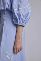 Camisa azul marino con bordados de flores blancas en mangas y falda.