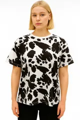 Remera de manga corta color beige con estampado de piel de serpiente en tonos marrones.