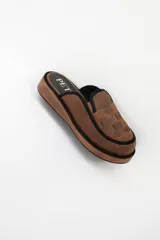 Zueco marrón de cuero con plataforma y detalle de tiras entretejidas en el empeine.