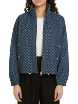 Campera azul marino con estampado de logos de Tommy Hilfiger en forma de rombos. Tiene cuello alto, cierre de cremallera, dos bolsillos laterales con botones, puños elásticos y cordón ajustable en el ruedo.
