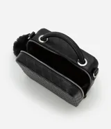 Cartera negra tipo camera bag con textura en relieve, correa de mano, asa desmontable y pompón colgante.